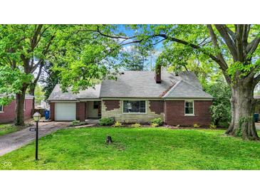 Charming brick home featuring a well-maintained lawn and lush green trees at 5840 Brouse Ave, Indianapolis, IN 46220