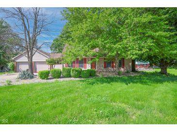 Charming single story home featuring a well manicured lawn, cozy curb appeal, and lovely red shutters at 6334 Teak Ct, Indianapolis, IN 46217