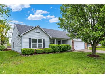 Charming single-story home boasts a manicured lawn and lush landscaping, enhancing its curb appeal at 7156 Chemistry Ct, Indianapolis, IN 46239