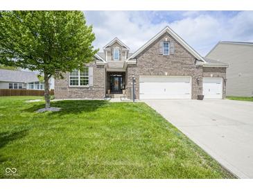 Beautiful brick home with a well-manicured lawn and a two-car garage on a sunny day at 7632 Nestucca Trl, Noblesville, IN 46062