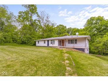Ranch home with an open yard, surrounded by mature trees at 9170 W Old Nashville Rd, Columbus, IN 47201