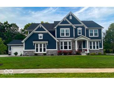 Beautiful two-story home featuring stone accents, a well-manicured lawn, and a classic blue facade at 1050 Windsor Estates Ct, Westfield, IN 46074