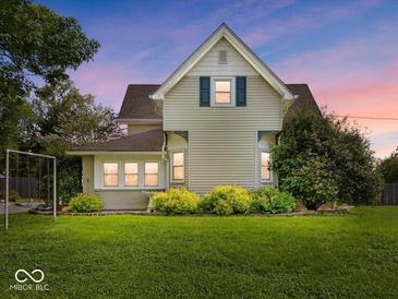 Charming home featuring a well-manicured lawn and delightful landscaping at dusk at 116 E Railroad St, Fountaintown, IN 46130