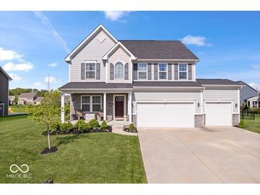 Charming two-story home featuring gray siding, a three-car garage, well-manicured lawn and stone accents at 13410 Mancroft Dr, Fishers, IN 46037