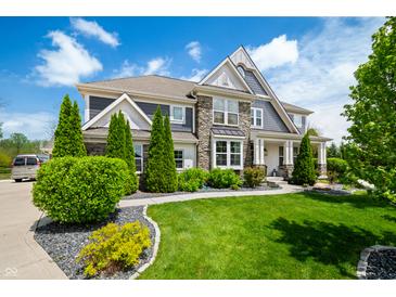 Beautiful two-story home with stone accents, lush landscaping, and a well-manicured lawn at 5990 Hollow Ct, Bargersville, IN 46106