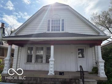 Traditional home featuring a quaint porch with decorative columns, windows, and fresh exterior paint at 616 N Exeter Ave, Indianapolis, IN 46222