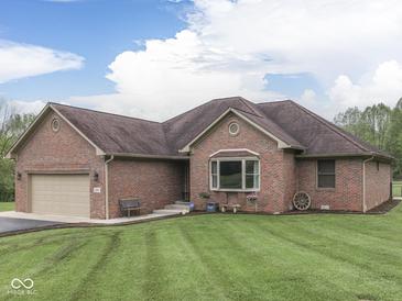 Charming brick home featuring an attached garage and a well-manicured lawn at 6494 N Baltimore Rd, Monrovia, IN 46157