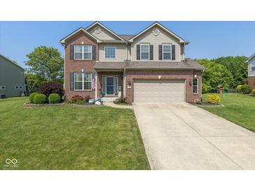 Charming two-story brick home with well-maintained landscaping and a two-car attached garage at 7140 Lakeland Trails Blvd, Indianapolis, IN 46259
