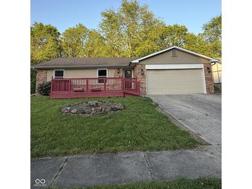 Charming single-story home with brick accents, red deck, a well-kept lawn, and an attached garage at 7627 Venetian Way, Indianapolis, IN 46217