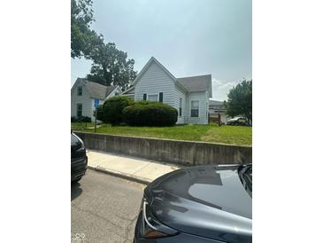 Charming front exterior showcasing white siding, neatly trimmed hedges, and an inviting curb appeal at 803 W 12Th St, Anderson, IN 46016