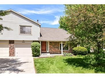 Charming two-story home with a brick and siding exterior, lush lawn, and a well-maintained front yard at 8980 Cinnebar Dr, Indianapolis, IN 46268