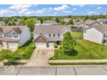 Expansive aerial view of a well-maintained home with a spacious driveway and lush landscaping at 9712 Brooks Dr, McCordsville, IN 46055