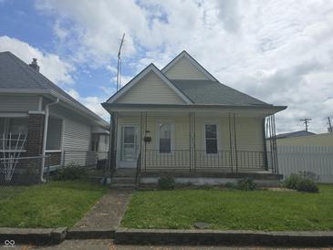 Charming single-Gathering home featuring a welcoming front porch and well-maintained lawn at 1131 S Pershing Ave, Indianapolis, IN 46221