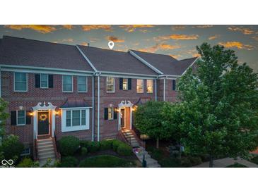 Charming brick townhome with manicured landscaping, covered entry, and welcoming front door at 13094 Overview Dr # 5D, Fishers, IN 46037