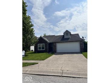 Charming one-story brick home with an attached two-car garage and well-manicured front lawn at 1639 Park Castle Way, Indianapolis, IN 46229