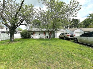 Ranch-style home featuring a well-maintained lawn, mature trees, and two driveways leading to attached garages at 2337 N Webster N Ave, Indianapolis, IN 46219