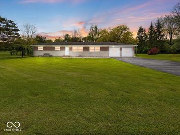Charming single story home with a brick facade, attached garage, and large front yard at 2399 E Mckay Rd, Shelbyville, IN 46176