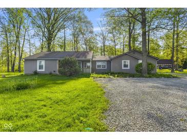 Charming single-story home with a gravel driveway and mature trees providing ample shade at 5039 Five Points Rd, Indianapolis, IN 46239