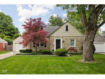 Charming stone home features a well-manicured lawn and a mature maple tree at 5439 Indianola Ave, Indianapolis, IN 46220