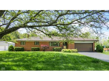 Charming brick home with an attached garage and well-manicured landscaping at 5683 Steven Dr, Greenwood, IN 46142