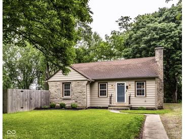 Charming single-story home featuring stone accents, a well-manicured lawn, and a cozy entryway at 6137 Evanston Ave, Indianapolis, IN 46220
