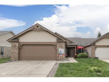 Charming single-story home featuring a well-manicured lawn, brick accents, and a two-car attached garage at 6503 E Walton Dr, Camby, IN 46113