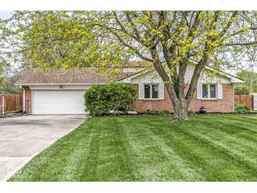 Charming brick home featuring a well-manicured lawn and mature trees, enhancing its curb appeal at 745 N Madison St, Fortville, IN 46040
