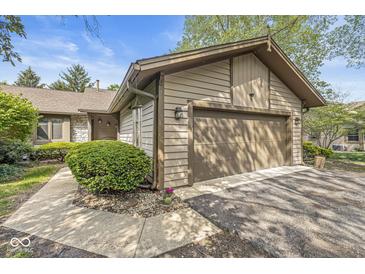 Charming exterior view features a two-car garage, attractive siding, and a well-manicured lawn at 8047 Van Ness Way, Indianapolis, IN 46240