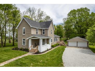Charming two-story home featuring a well-manicured lawn and detached two-car garage at 933 N 19Th N St, Elwood, IN 46036