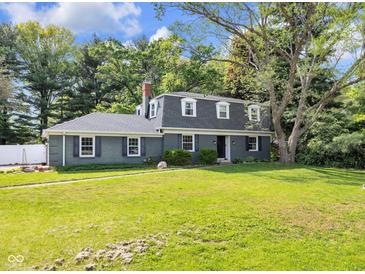 Charming two-story home featuring a well-maintained lawn and mature trees offering curb appeal at 9860 Sunnymeade Ln, Indianapolis, IN 46280
