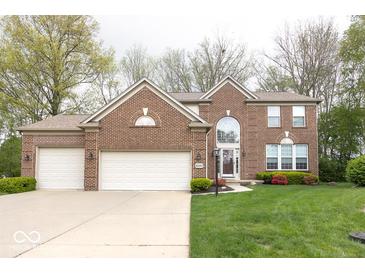 Charming two-story brick home with attached three-car garage and well-manicured front lawn at 12253 Bedrock Ct, Fishers, IN 46037