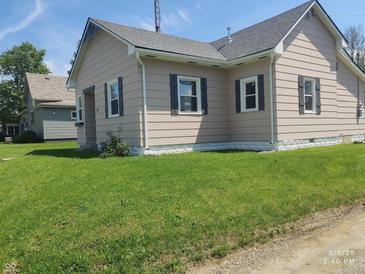Side view of the home showcasing the well-manicured lawn and residential neighborhood at 1527 N C N St, Elwood, IN 46036