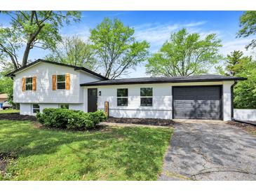 Charming home featuring white siding, black accents, a garage, and well-maintained landscaping at 1944 Galeston Ct, Indianapolis, IN 46229