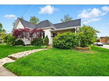 Charming home with a well-manicured lawn, stone pathway, and mature trees enhancing the curb appeal at 218 Pearl St, Fortville, IN 46040