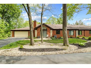 Charming brick home with manicured landscaping and inviting entrance, with a circular driveway at 2922 Amherst St, Indianapolis, IN 46268