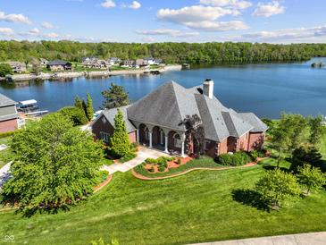 Beautiful waterfront property featuring a meticulously landscaped lawn and manicured garden beds at 3107 Waterfront Cir, Anderson, IN 46012