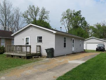 Cozy home with neutral siding, front porch, and long driveway leading to a detached garage at 470 N Pine St, Morgantown, IN 46160