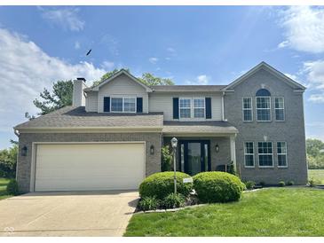 Traditional two-story home with a gray brick facade, well-manicured lawn, and an attached two-car garage at 523 Torrey Ct, Avon, IN 46123
