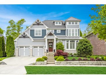 Stunning two-story home featuring a meticulously landscaped front yard and a three-car garage at 6734 W Stonegate Dr, Zionsville, IN 46077