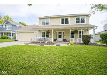 Charming two-story home featuring a welcoming front porch, manicured lawn, and an attached garage at 7249 Tappan Dr, Indianapolis, IN 46268