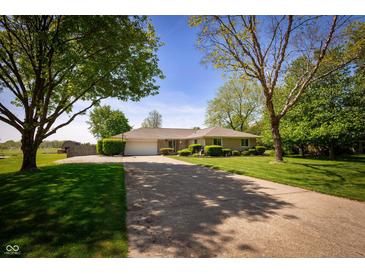 Charming ranch home with mature trees, a long driveway, and a well-maintained front lawn at 7285 E County Road 900 N, Brownsburg, IN 46112