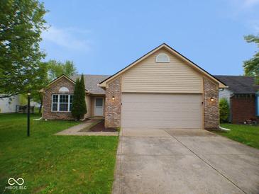 Charming single-story home with a brick and vinyl exterior, two-car garage and well-manicured lawn at 9125 Bagley Way, Indianapolis, IN 46231