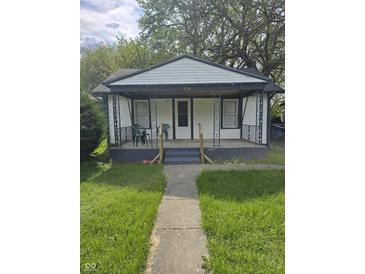Charming single-story home with a cozy front porch and well-maintained lawn at 114 S Catherwood Ave, Indianapolis, IN 46219