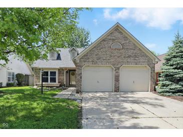 Charming brick home featuring a two-car garage, dormer windows, and manicured lawn at 14634 Village Park East Dr, Carmel, IN 46033