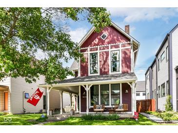 Charming two-story home featuring a welcoming front porch, red siding, and well-maintained landscaping at 1630 N New Jersey St, Indianapolis, IN 46202