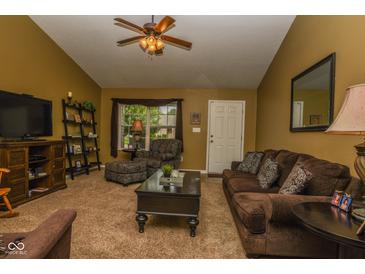 Cozy living room with brown sofa, coffee table, ceiling fan, and large front window at 270 Rapid Rill Ln, Brownsburg, IN 46112