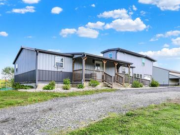 Inviting two-story home with a covered porch and a well-maintained gravel driveway at 3682 S 380 E, Anderson, IN 46017