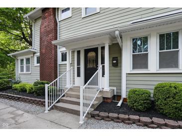Close-up view of the front door with white railings and fresh landscaping at 4447 N College Ave, Indianapolis, IN 46205