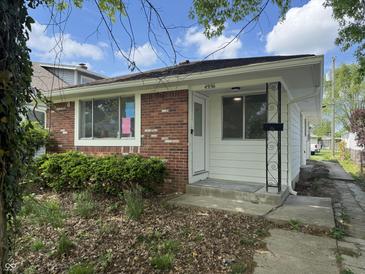 Charming single-story home featuring a brick facade and a well-maintained front yard at 4956 W 11Th St, Speedway, IN 46224
