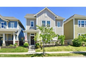 Charming two-story home with a well-maintained lawn, landscaped garden, and inviting front porch at 5755 Buskirk Dr, Indianapolis, IN 46216